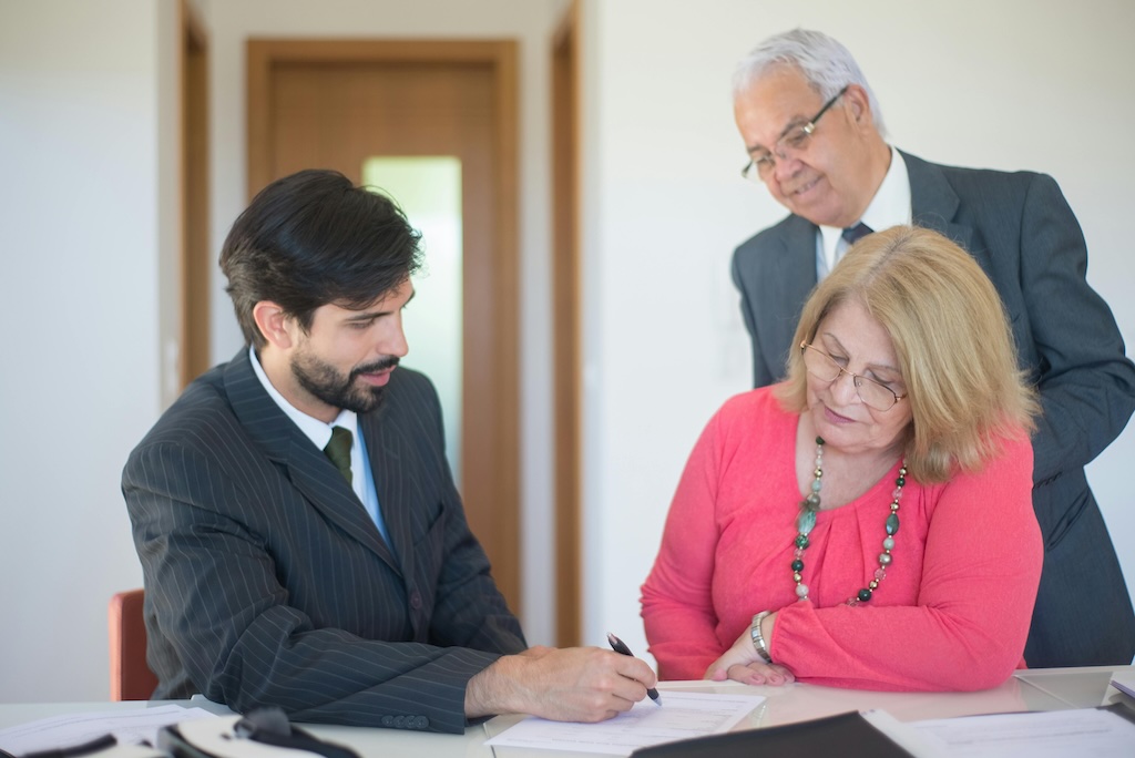 Man showing documents to elderly couple, representing estate plan notary signing