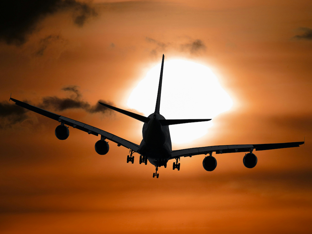 Airplane flying into the sunset, representing a Golden Visa apostille