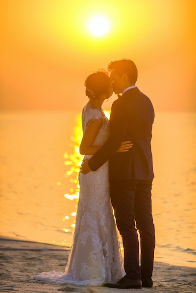 Bridge and groom kissing on a beach, symbolizing a certified copy of a marriage certificate from San Francisco County.